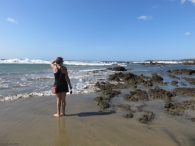 Karen surveys the scene with her bare feet in the wet sand.